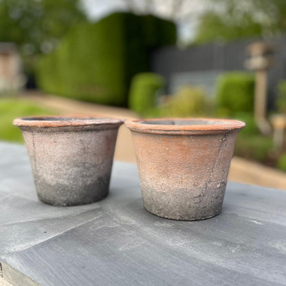With its aged finish and simple, earthy charm, our small rustic terracotta pot is a timeless addition to any shelf, windowsill or garden nook. Stled in garden.