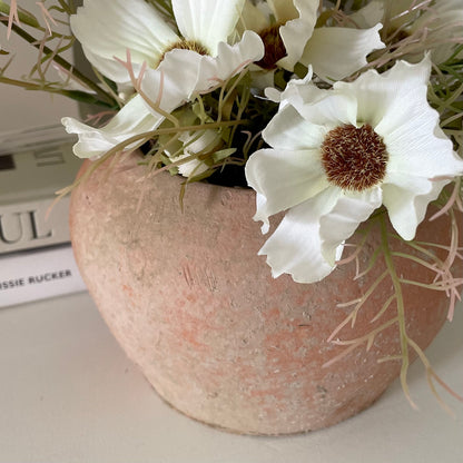 Stanton terracotta pot styled with cosmos flowers. On a shelf with home decor books.