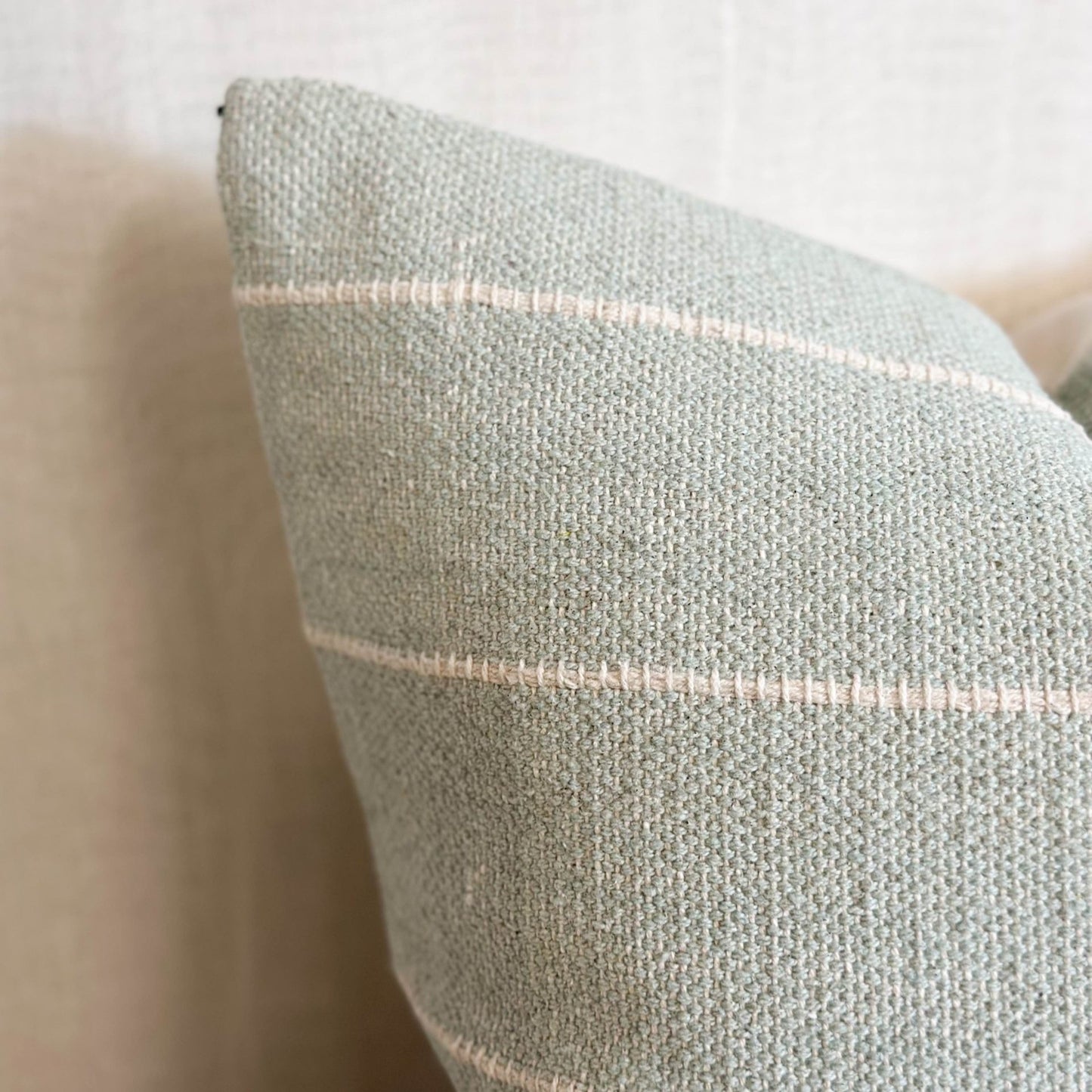 Soft cotton sage green cushion with subtle stripes, perfect for layering on sofas, chairs or beds.