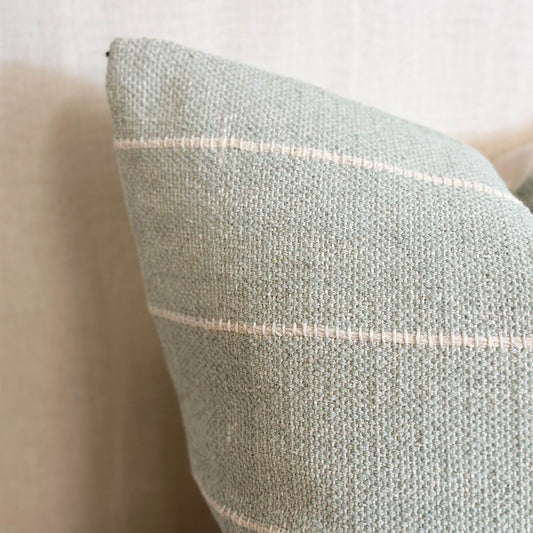 Soft cotton sage green cushion with subtle stripes, perfect for layering on sofas, chairs or beds.
