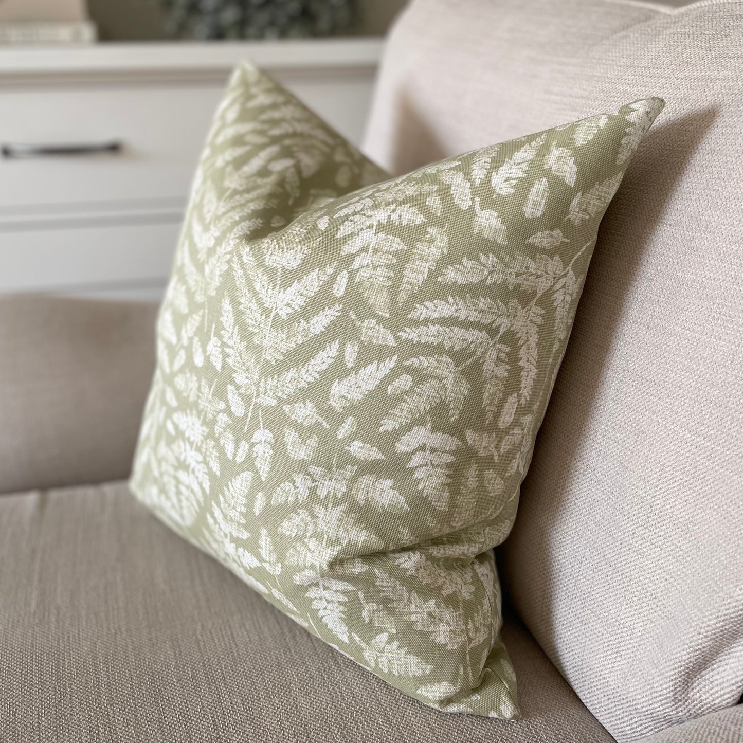 Decorative cushion with subtle fern print, perfect for layering in a calm, neutral interior.