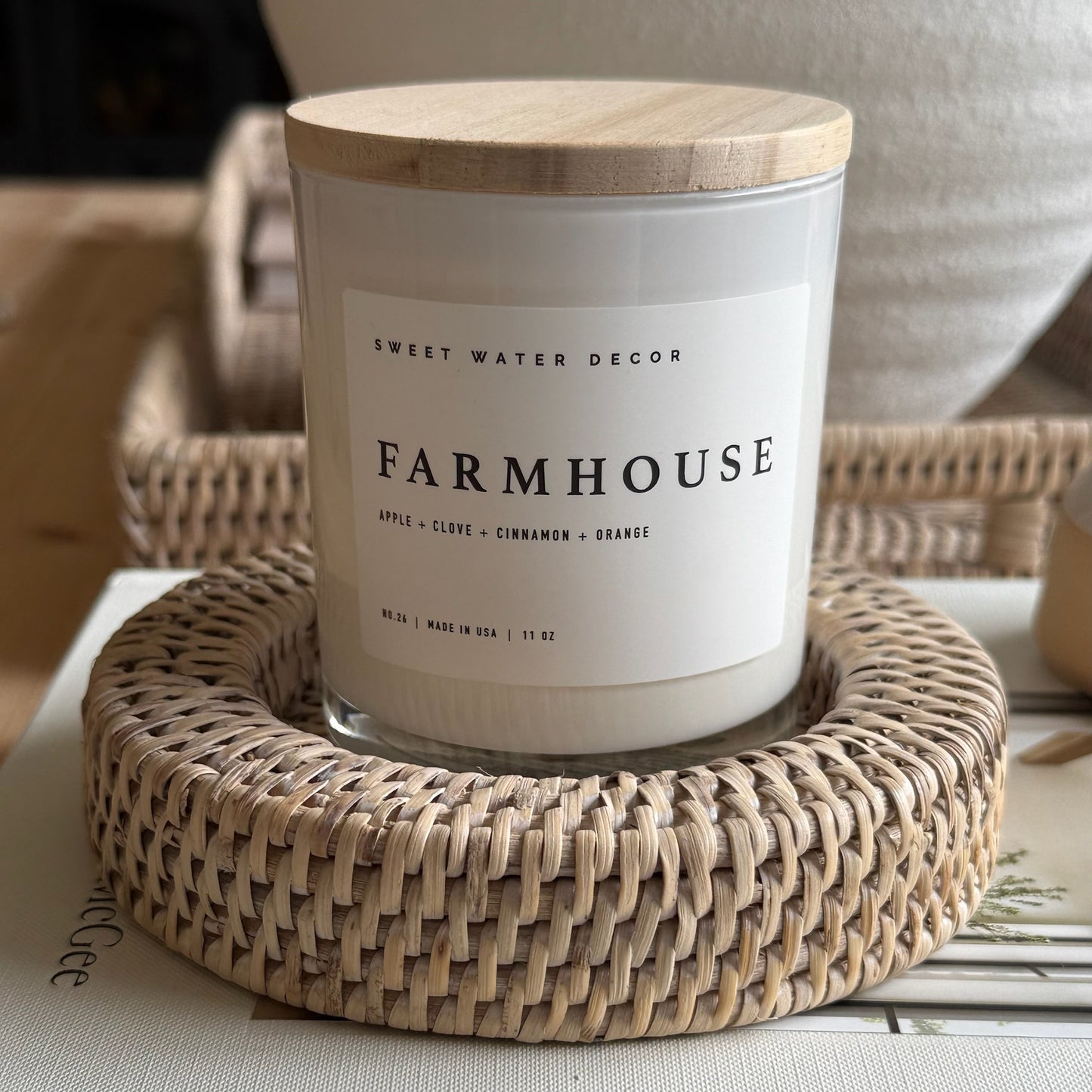 Farmhouse candle in rustic glass jar surrounded by autumnal accents, evoking warm notes of apple, cinnamon, and vanilla.