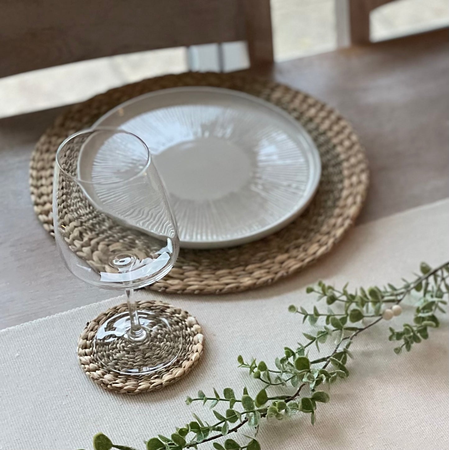 Eco friendly seagrass and water hyacinth coasters paired with matching placemats. Styled on a white linen tablecloth.
