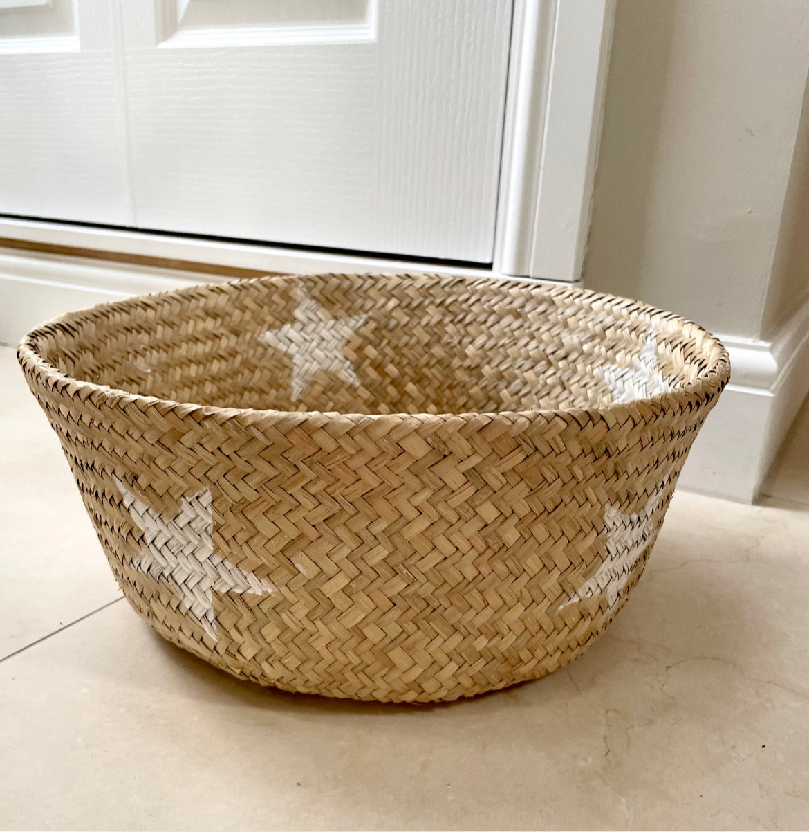 Handmade star detailed seagrass basket with natural woven texture.