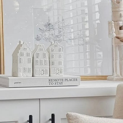 Decorative scene with 3 white houses that look like canal dutch style houses and a sign on a shelf.