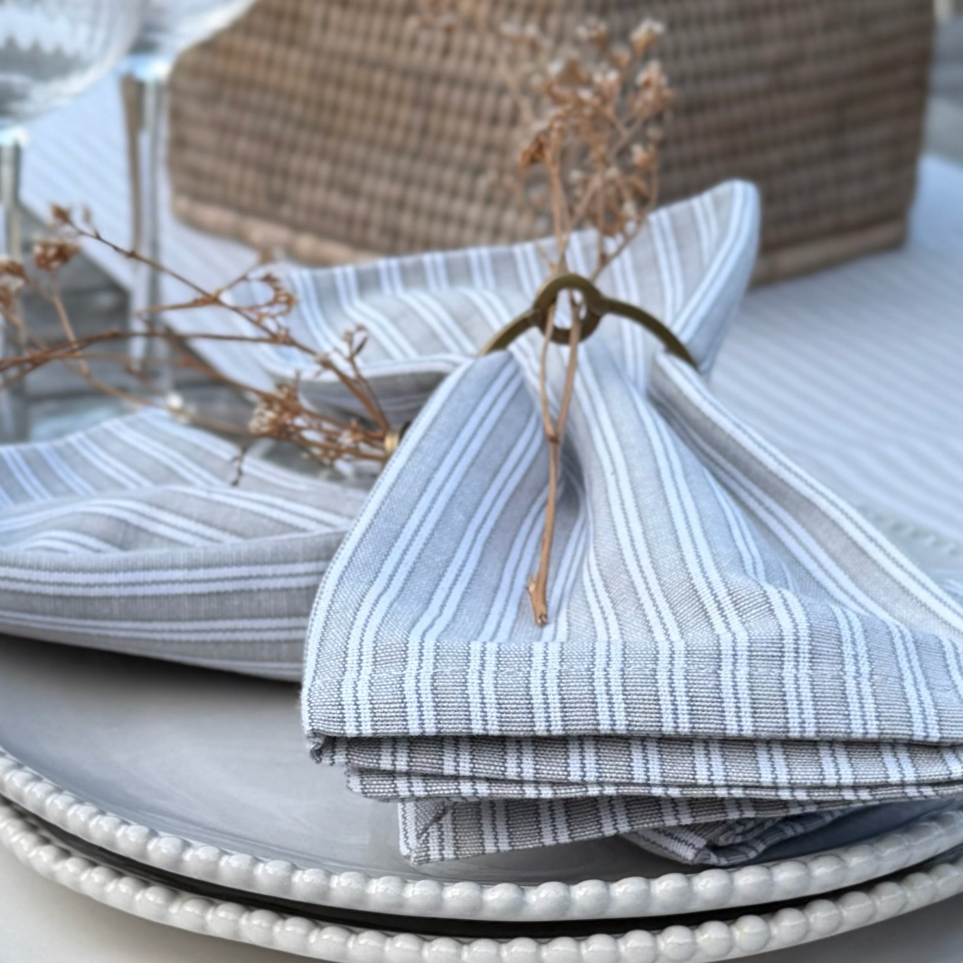 Grey and white striped cotton napkins styled with a matching table runner, perfect for everyday dining or relaxed gatherings.