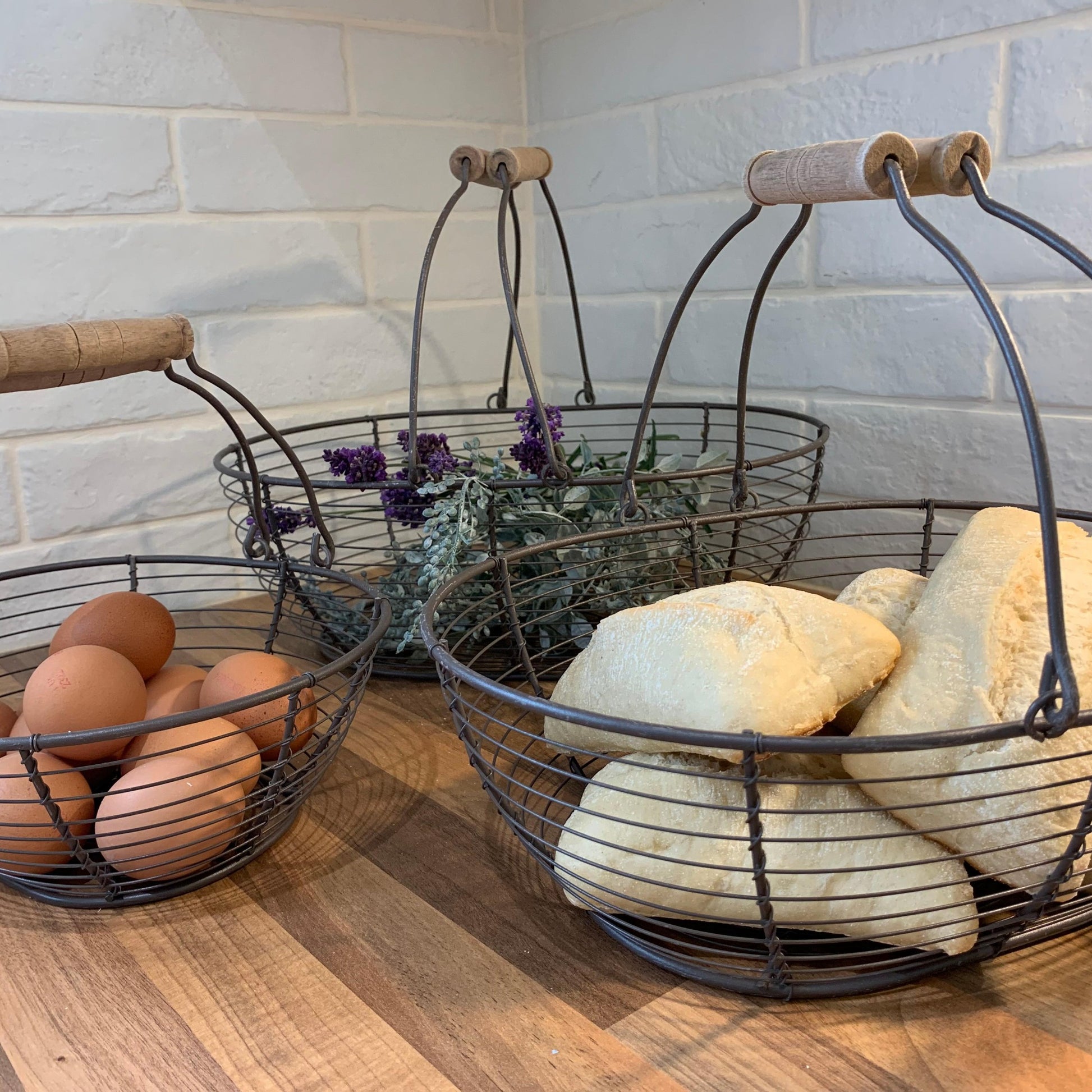 Sturdy metal wire basket with wooden handles, perfect for storing eggs or small kitchen essentials.