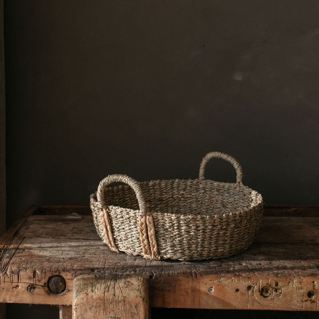 Shallow seagrass basket showcasing its natural weave and textured finish, perfect for styling with decor or seasonal accents.
