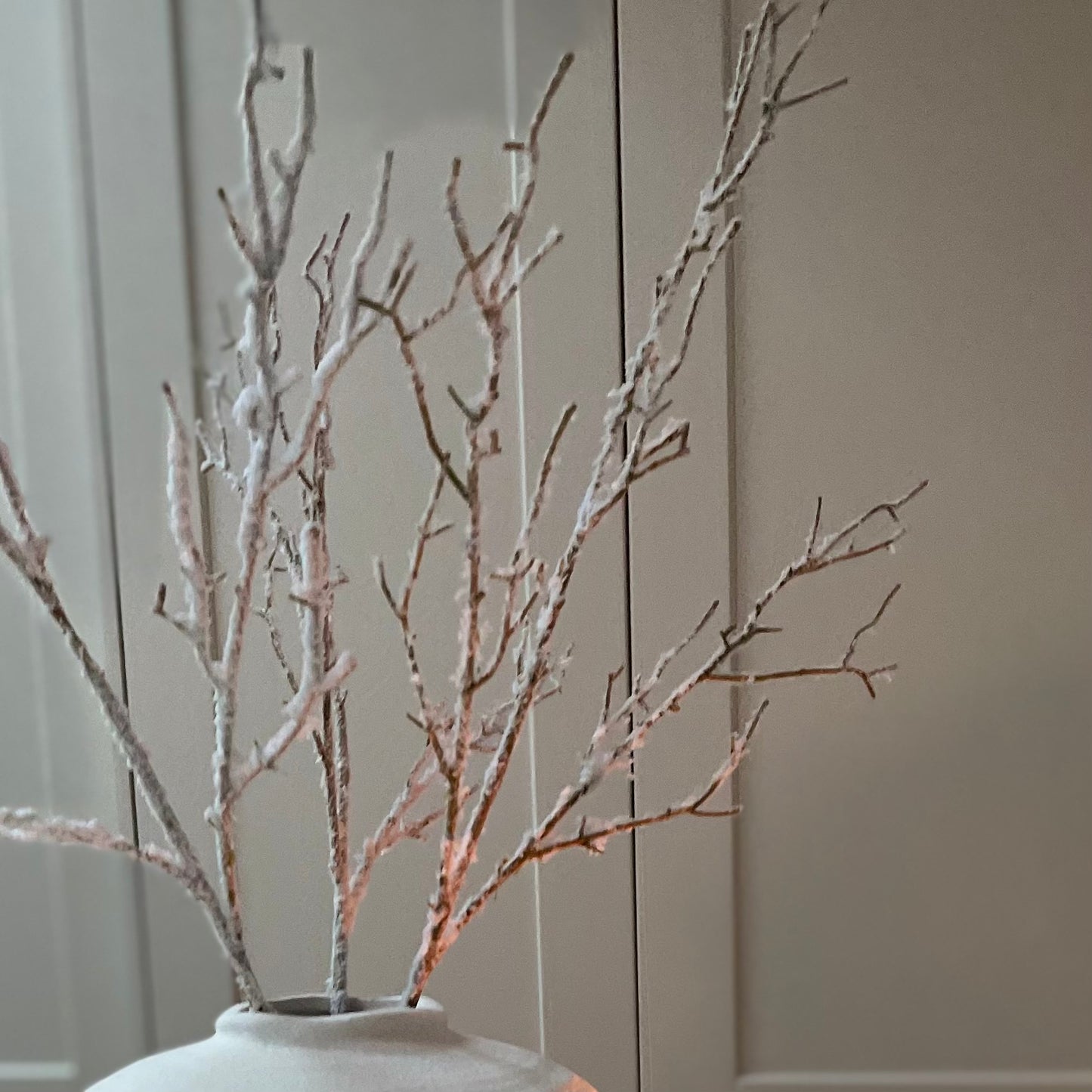 Close up of snowy faux branch texture in a white matte ceramic regola vase.
