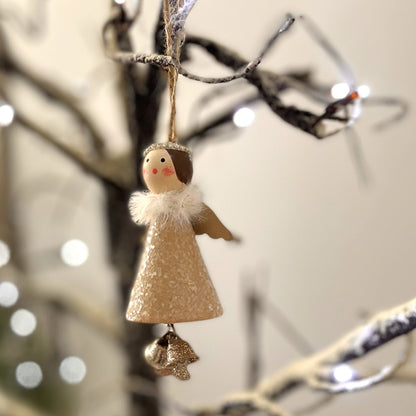 Christmas angel decoration with glitter detail and bells for feet. Hanging on a twinkling snowy branch.