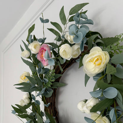 Pink and cream rose wreath with green foliage on rustic grapevine wreath.
