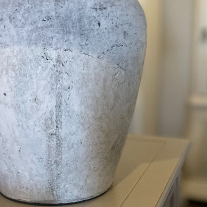 Close up of distressed stone base on Darcy lamp shown on a hallway console table.