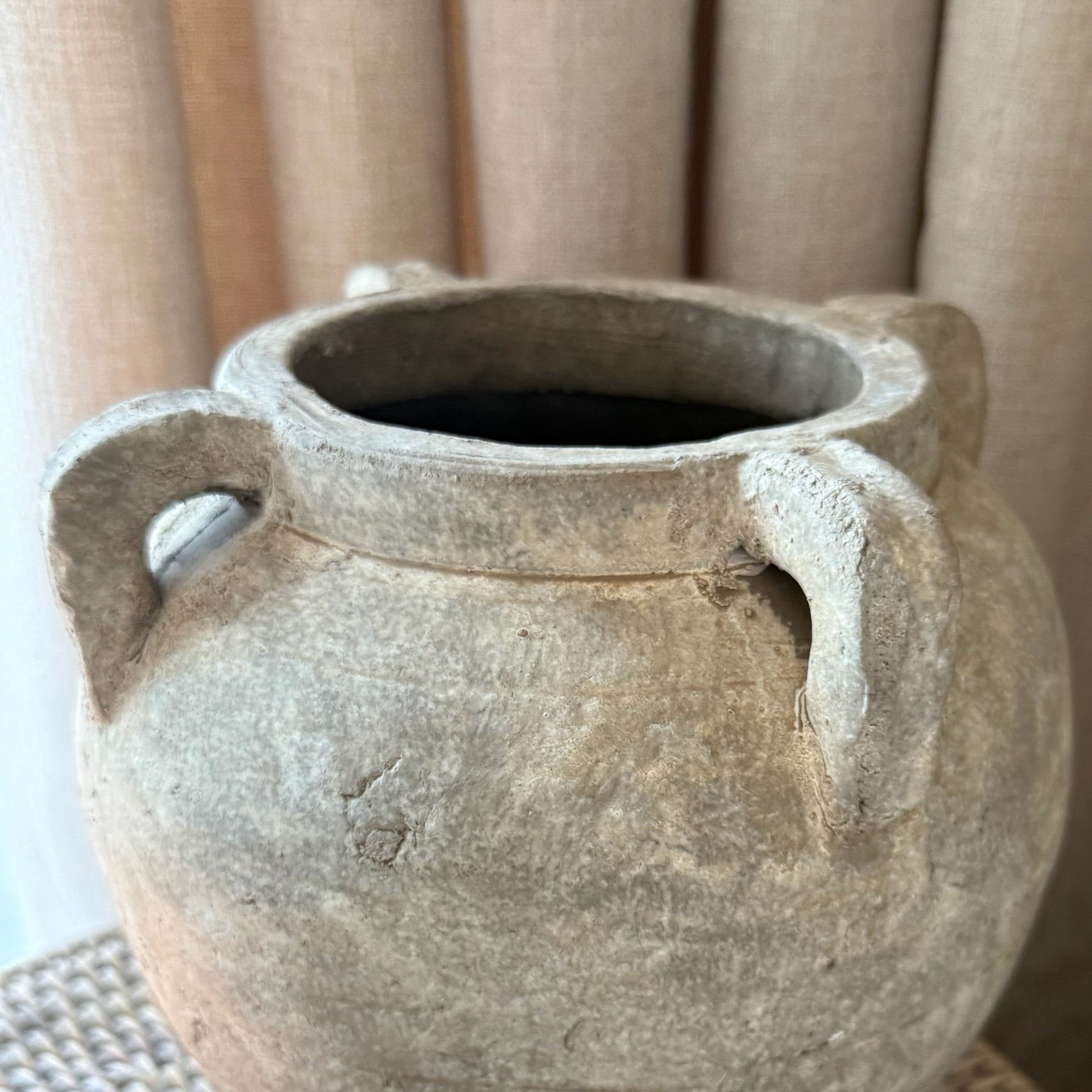 Vintage-style terracotta pot with handles on a neutral background