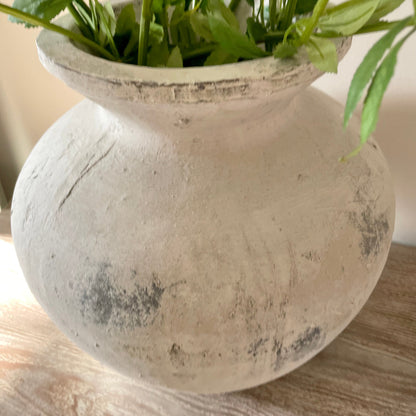 Darcy stone textured vase in white and grey tones styled with faux flowers on a rustic wooden table.