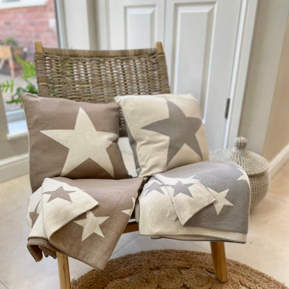 Taupe and ivory soft throw with star detail. Styled on a chair with matching cushion. Other colour styled too in range.
