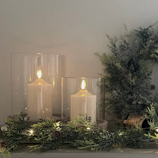 Rustic glass and earthy tone hurricane candle holder adding warmth to a neutral living space.