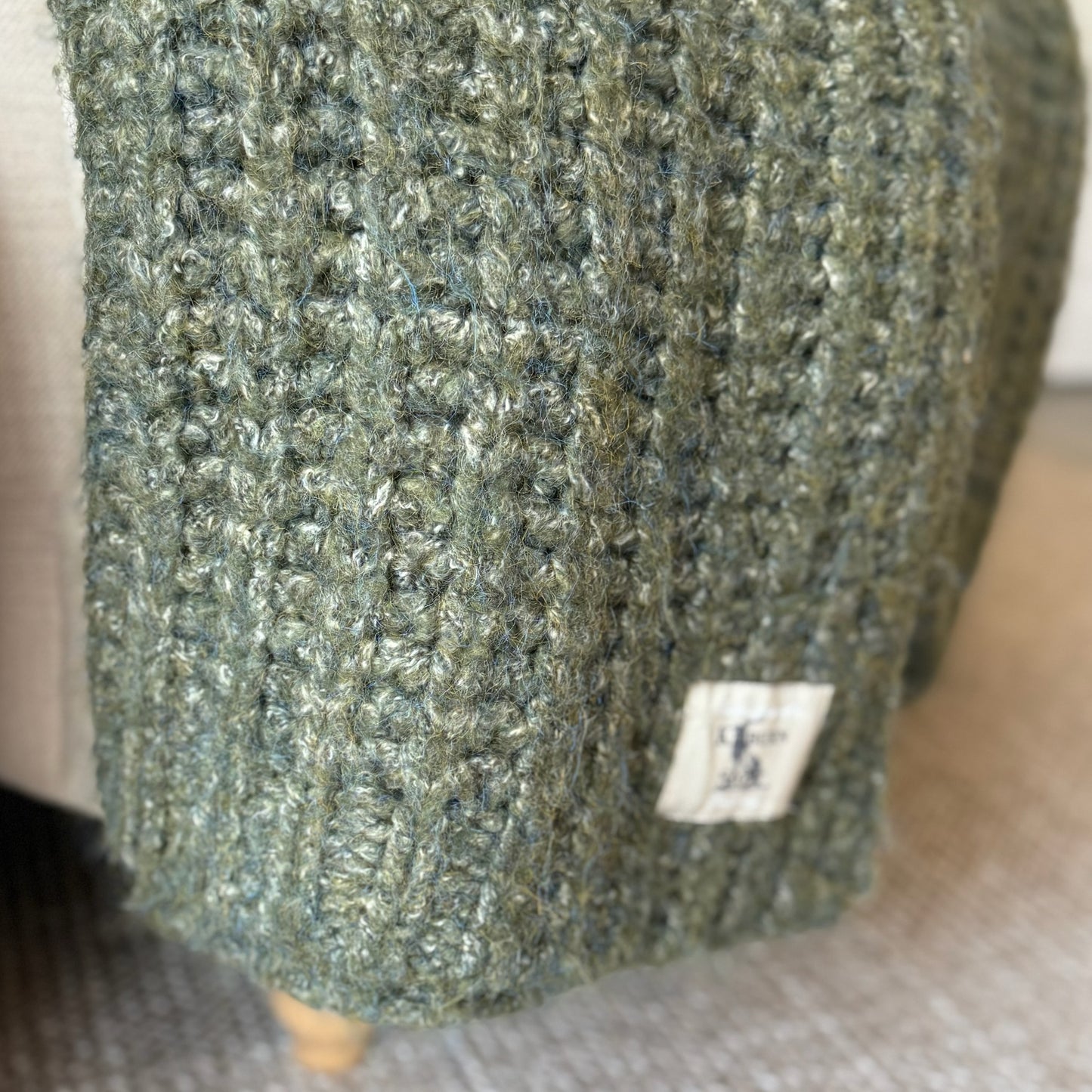 Decorative deep green throw with rich melange texture, perfect for cosy layering in neutral or seasonal interiors.