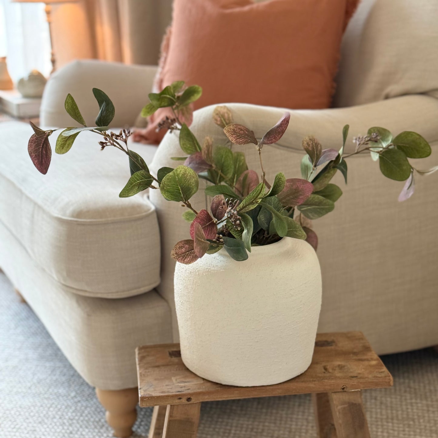 Artificial eucalyptus foliage stem with soft greens and ruby tones, perfect for vase or floral arrangements.