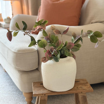 Artificial eucalyptus foliage stem with soft greens and ruby tones, perfect for vase or floral arrangements.