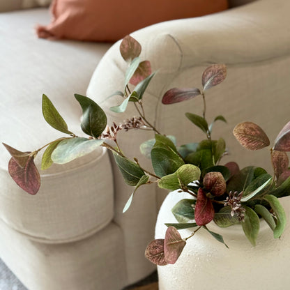 Artificial eucalyptus foliage stem with soft greens and ruby tones, perfect for vase or floral arrangements