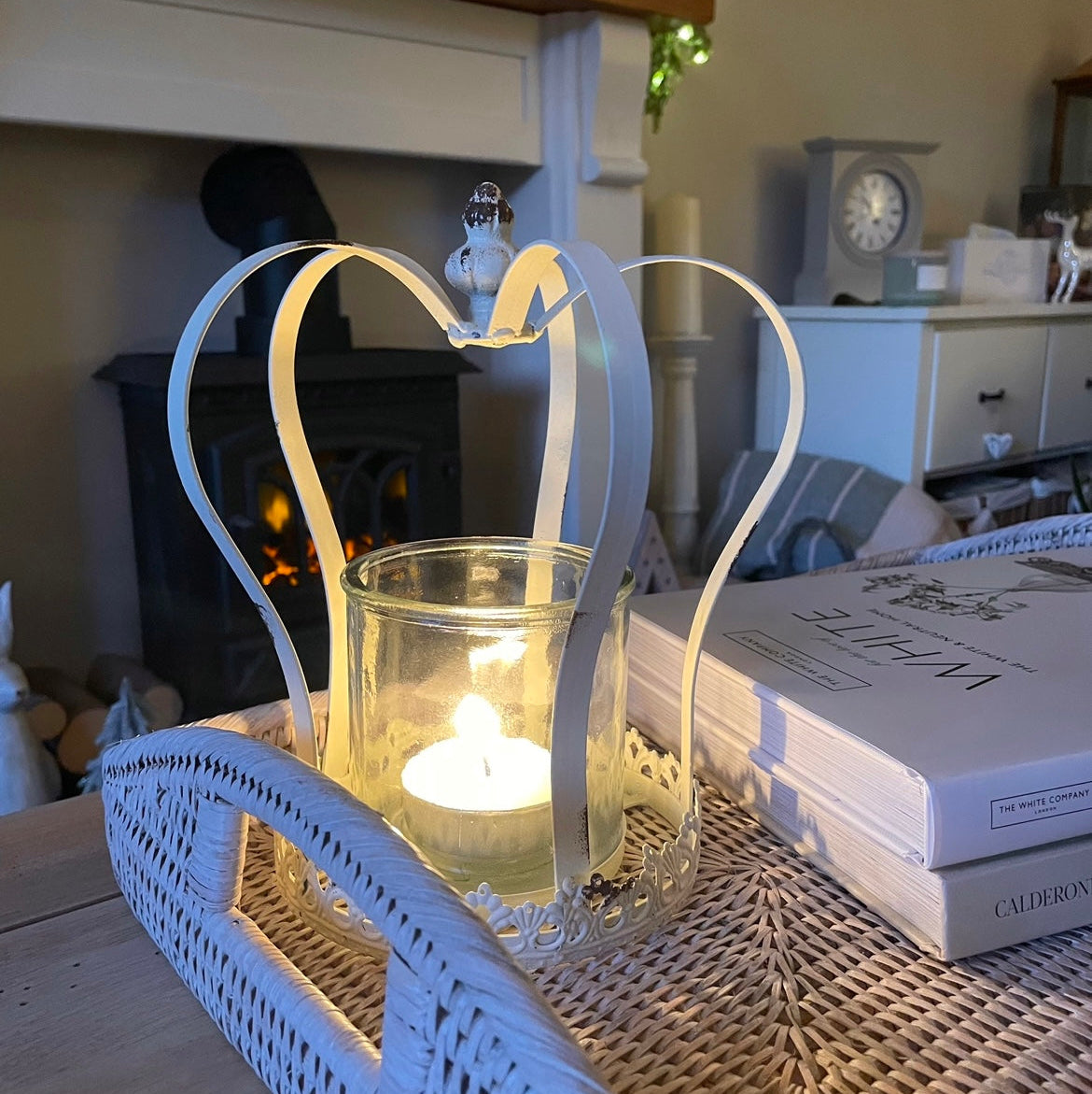 Antique style distressed white metal crown candle holder with removable glass insert, styled on rattan tray.
