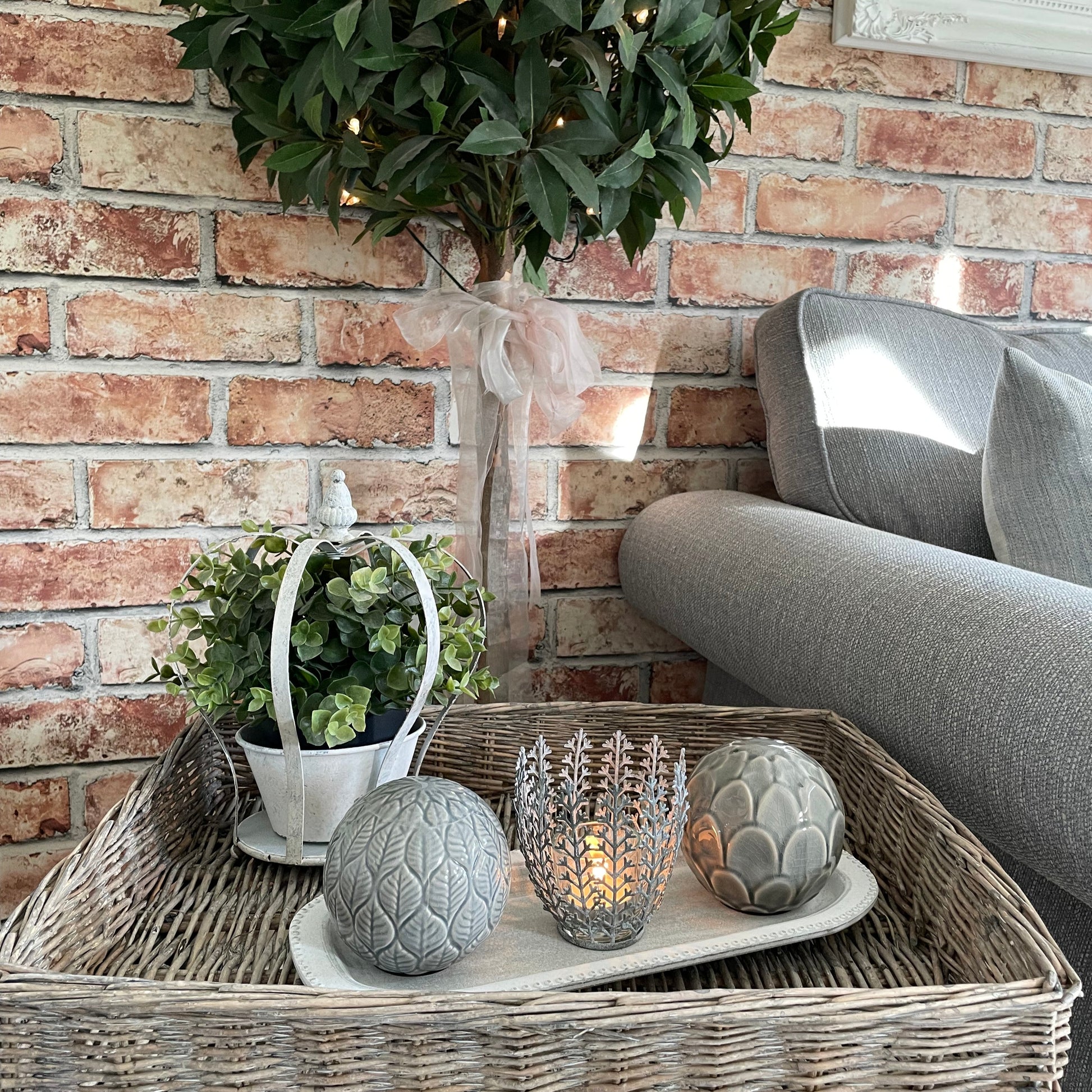 Decorative candle holder shaped like a crown with a lit candle on a tray with decorative accessories.