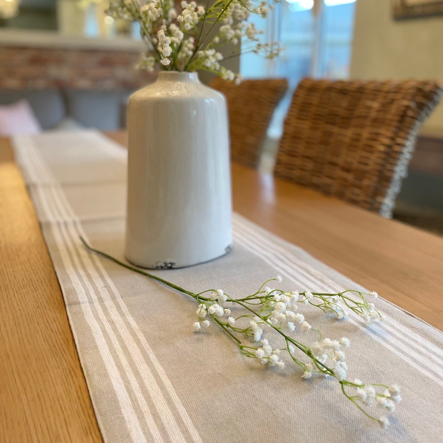 Faux white gypsophila stems arranged in a vase, styled with five stems.