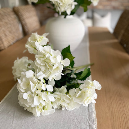 Lush white faux hydrangea bouquet, ideal for dining tables, windowsills, or coffee tables in neutral interiors.