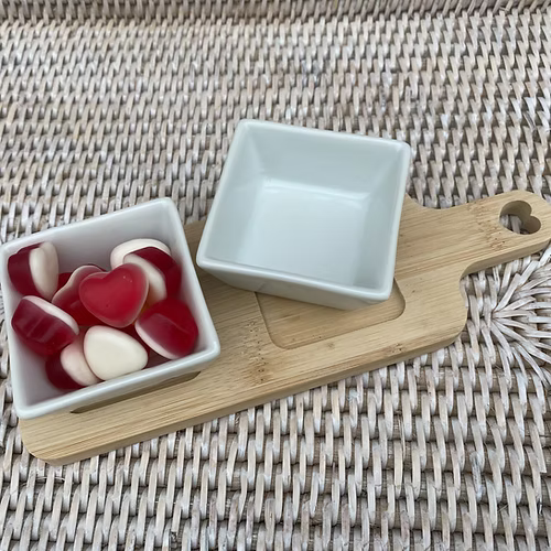 Bamboo serving board set with white dishes, ideal for home entertaining and stylish presentation.