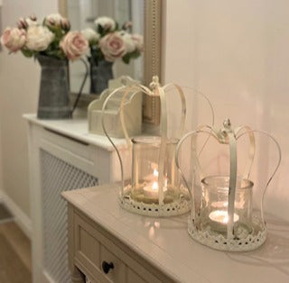 Antique style distressed white metal crown candle holders with removable glass insert, styled on a hallway console table..