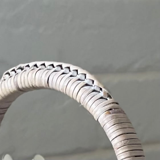 Close up of whitewashed rattan weave on table caddy handle.