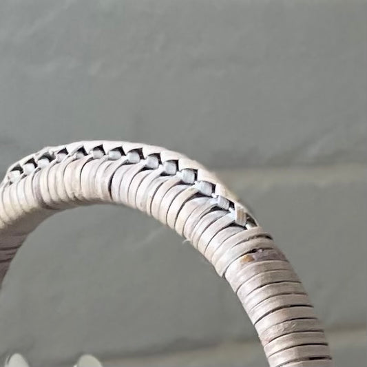 Close up of whitewashed rattan weave on table caddy handle.