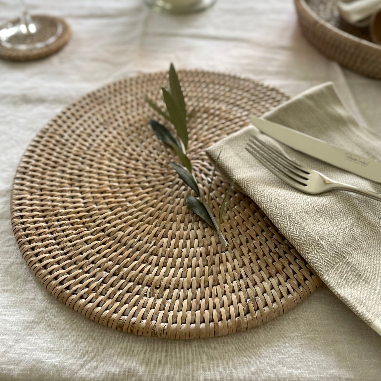 Natural rattan placemats for casual and formal dining. Styled on a white linen tablecloth.