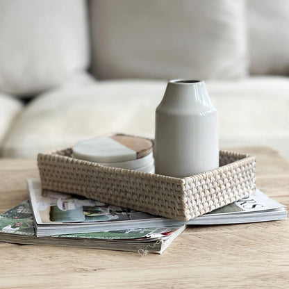 Whitewashed small rectangular rattan tray styled with vase and candles.