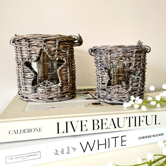 Woven wicker candle holder with star cut-out and glass insert, styled with a tea light candle.