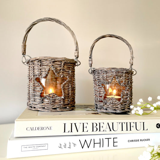 Woven wicker candle holder with star cut-out and glass insert, styled with a tea light candle.