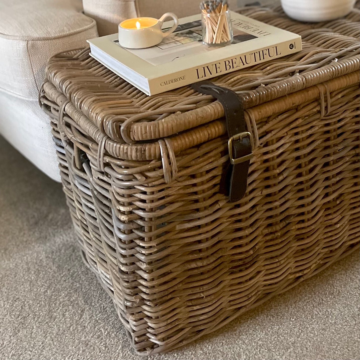 Rustic wicker trunk used for blanket and toy storage. Styled in a living room.
