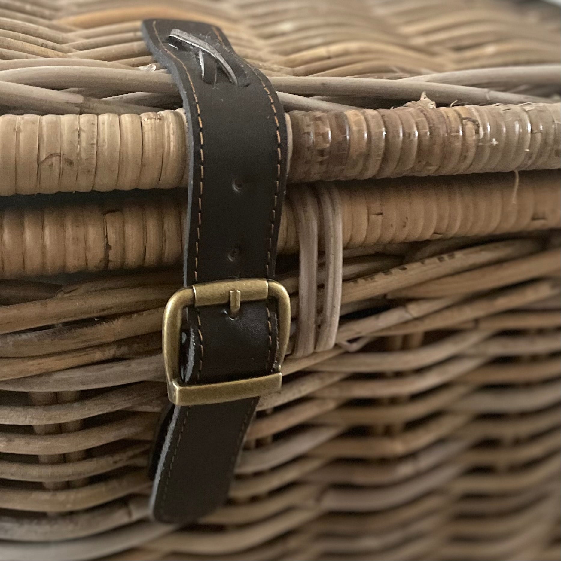 close up of wicker trunk leather straps.