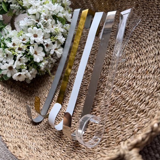 Assorted coloured metal wreath holders displayed together, showcasing their sturdy design and versatile home decor use.