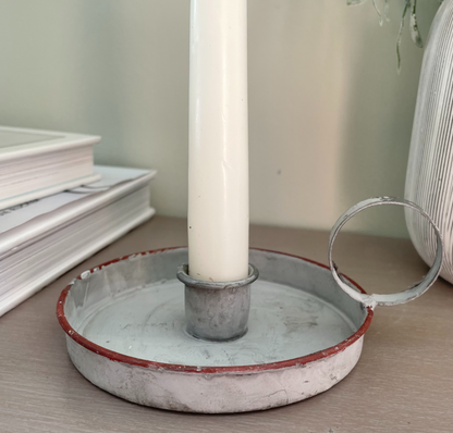Grey washed wee willie winkie zinc candle holder styled with a taper candle on a console table.